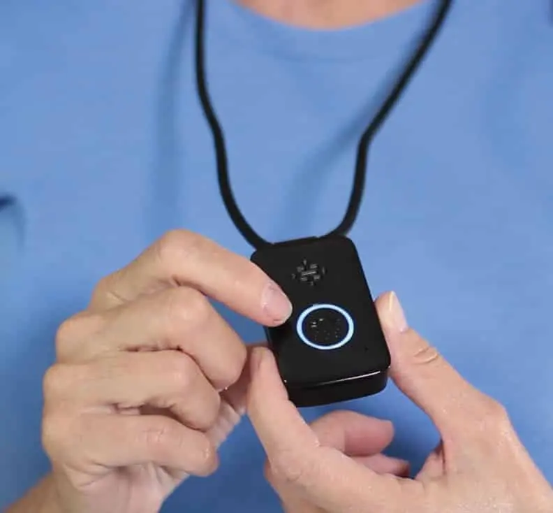 Senior holding the Belle+ pendant to press the call button