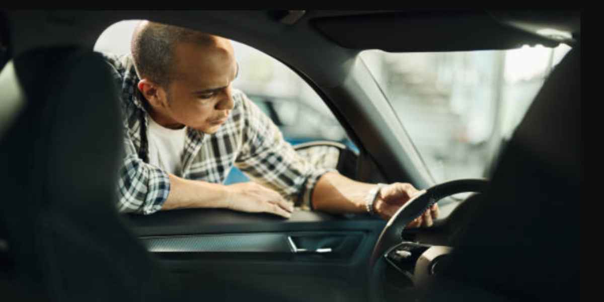 man finding car tracker inside the car